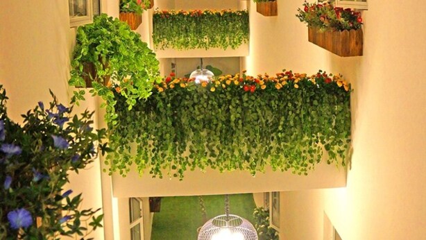 Ein mehrstufiger Außenbalkon mit verschiedenen Blumentöpfen und Blumen.