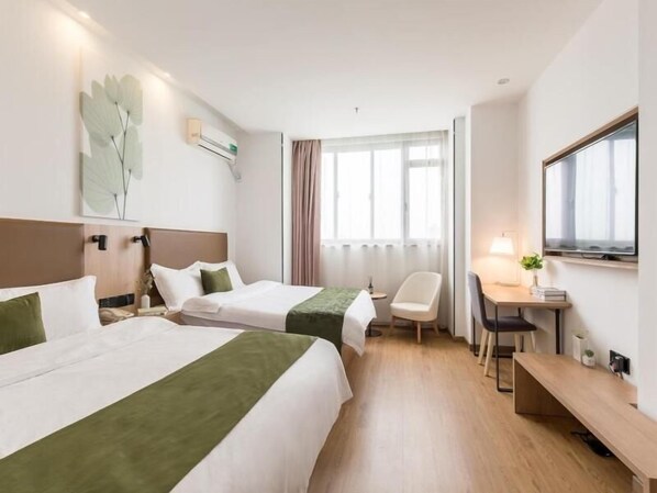 A hotel room with two beds, a desk, a chair, and a large window.