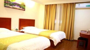 A hotel room with two beds, a wooden headboard, a desk with a chair, and a window with curtains. - Greentree Inn District Jiangqiao Jinyun Road Metro (Shanghai)