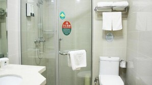 A bathroom with a glass-enclosed shower, a toilet, and a sink. There are towels hanging on a rack and a soap dispenser on the wall. - Greentree Inn District Jiangqiao Jinyun Road Metro (Shanghai)