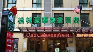 A hotel entrance with a signboard displaying the hotel's name and amenities. - GreenTree Inn Shanghai Pudong Airport Heqing Huanqing Middle Road Express Hotel (Shanghai)