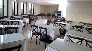 A spacious restaurant with multiple tables and chairs, large windows, and a modern interior design. - GreenTree Inn Shanghai Pudong Airport Heqing Huanqing Middle Road Express Hotel (Shanghai)