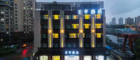 A multi-story hotel with illuminated vertical lines and signage indicating it is a hotel.
