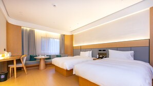 A hotel room with two beds, a desk, a chair, and a small table. - Greentree Inn Site South Yanggao Road Subway Stati (Shanghai)
