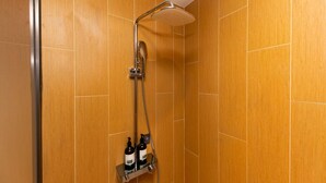 A shower with a handheld showerhead and a wall-mounted rain showerhead, with two bottles of shampoo and conditioner on a shelf below. - Greentree Inn Site South Yanggao Road Subway Stati (Shanghai)