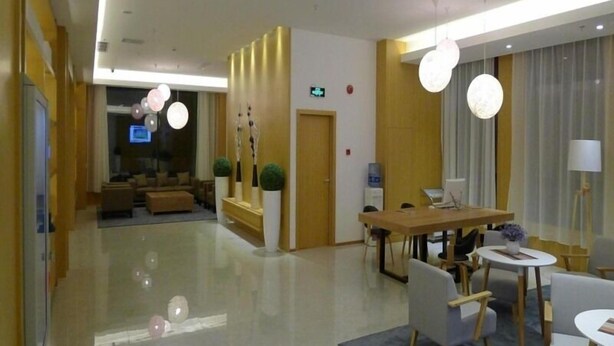 Eine moderne Hotelhalle mit Empfangsbereich, Sitzgelegenheiten und einem Essbereich.
