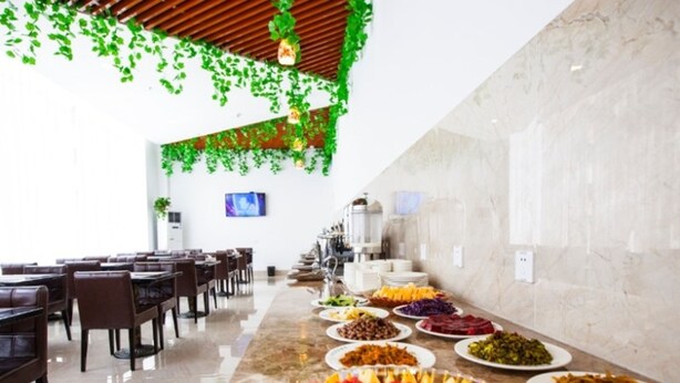 A buffet setup with various dishes and a long table. - GreenTree Inn Yancheng Dongtai Huiyang Road Guofu Hotel (Yancheng)