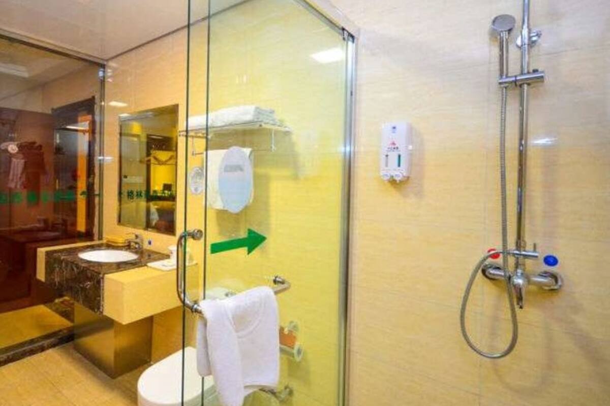 Ein modernes Badezimmer mit Glastrennwand, Waschbecken, Toilette und Duschbereich.