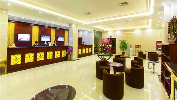 A hotel lobby with a reception desk, seating area, and a large decorative globe.