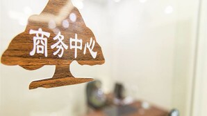 A wooden sign with Chinese characters, likely indicating a business or service center.