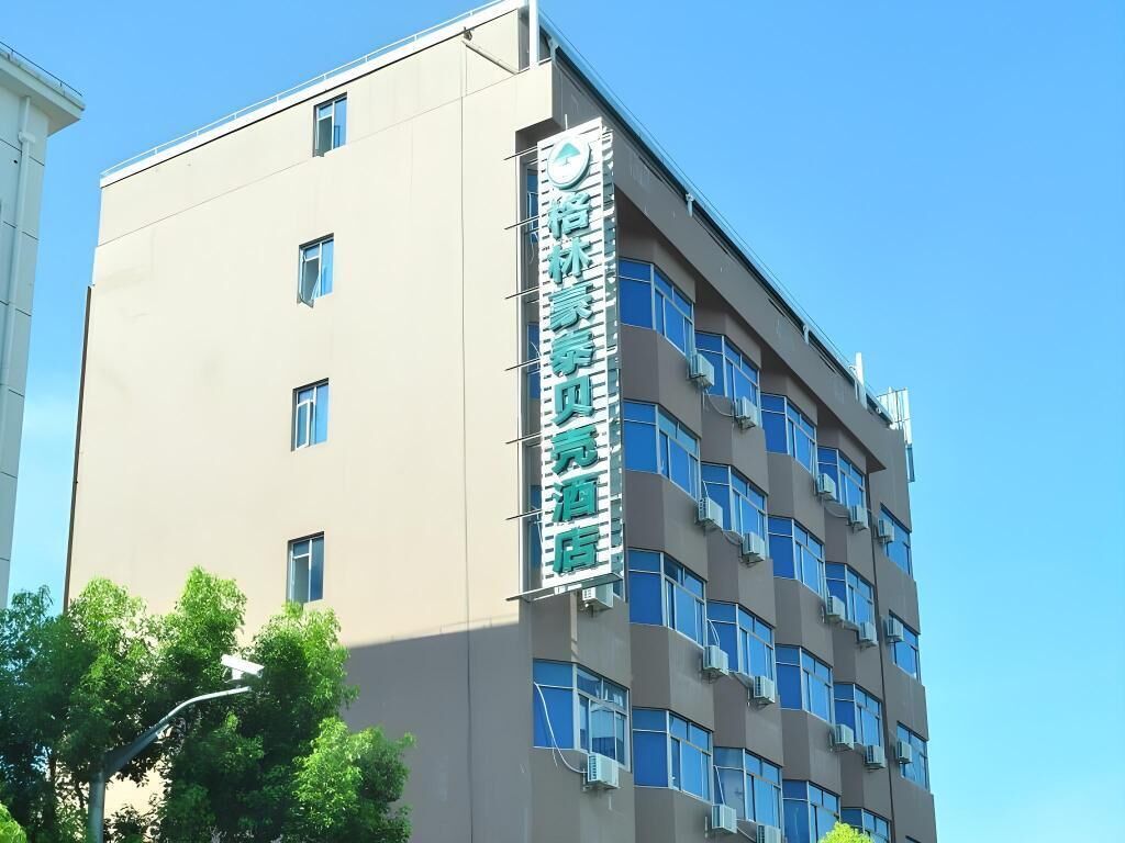 Un edificio de varios pisos con un letrero llamativo en la pared.