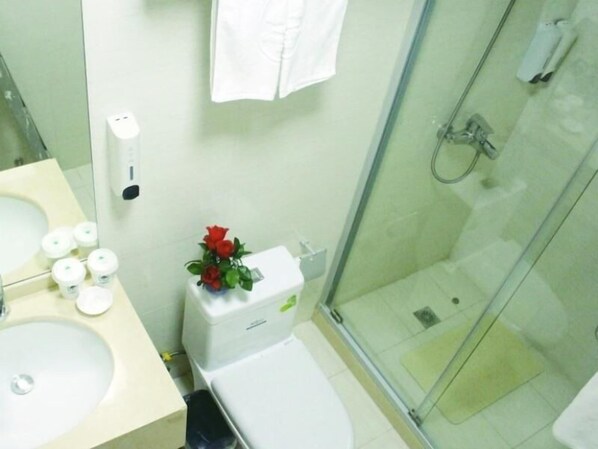 A bathroom with a sink, toilet, and glass shower enclosure. - GreenTree Shell Hotel (Shanghai Zhuanqiao Metro Station) (Shanghai)