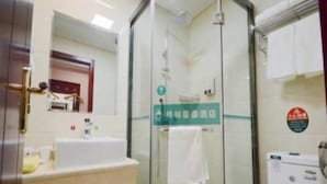A modern bathroom with a glass shower enclosure, a white sink, and a toilet.