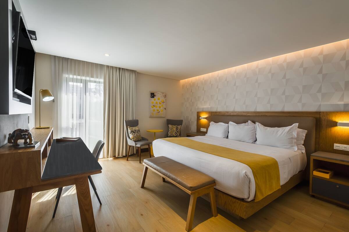 Een moderne hotelkamer met een groot bed, een bureau, een stoel en een bank.