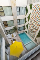 Una piscina al aire libre, sombrillas, sillones reclinables de piscina