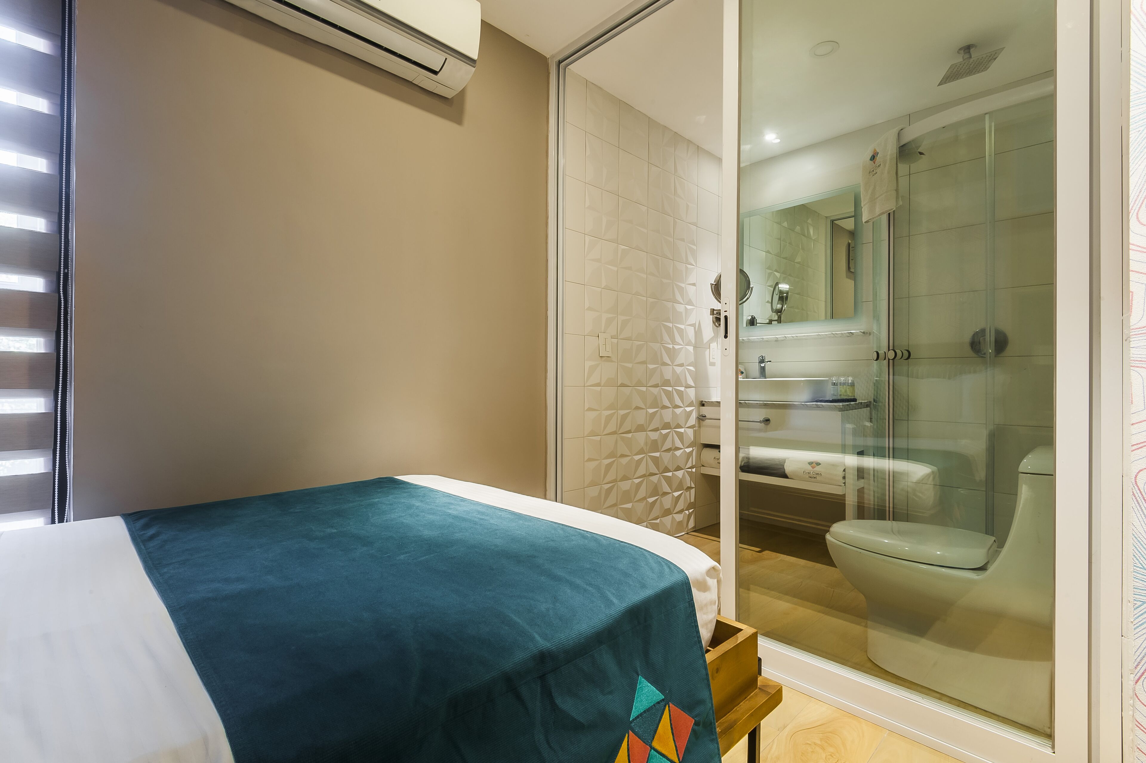 A bedroom with a bed, a bathroom with a shower, and a toilet.