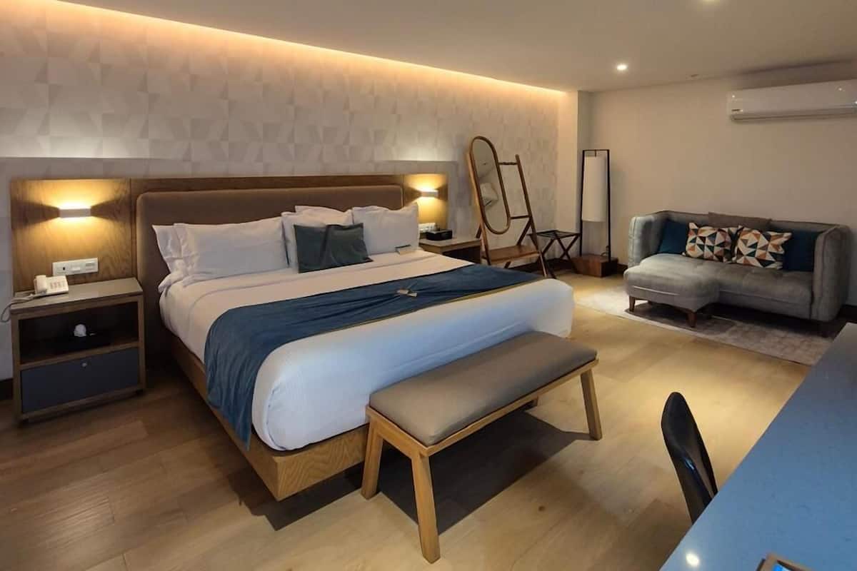 Een moderne slaapkamer met een bed, nachtkastjes, een bureau en een stoel.