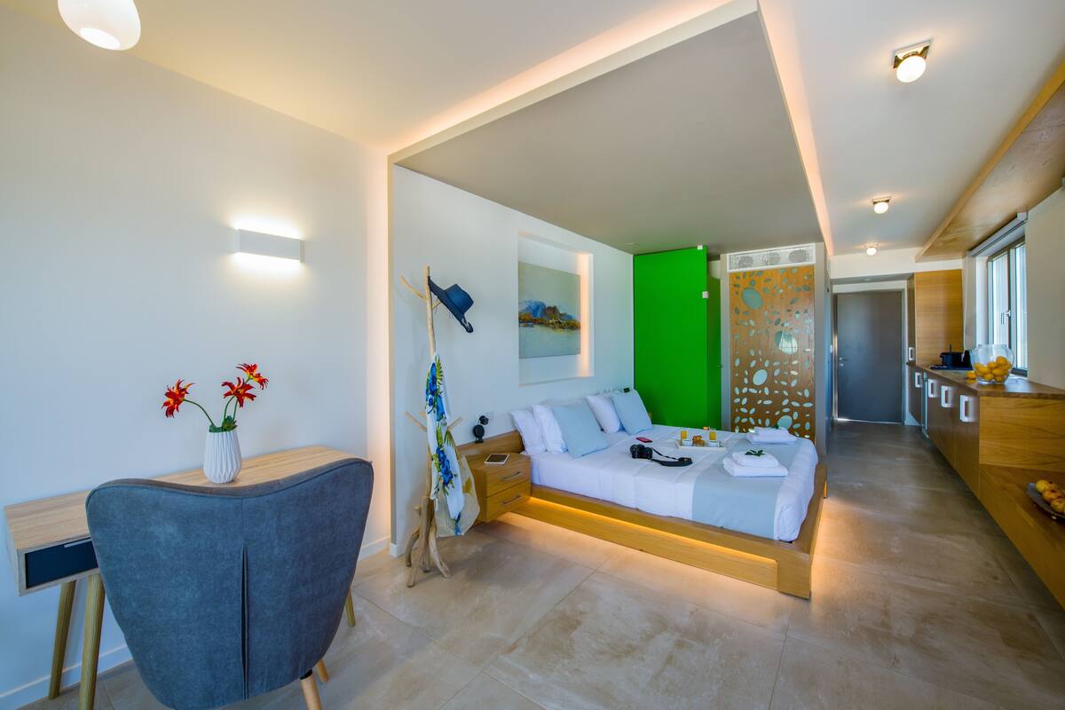 Une chambre d’hôtel moderne équipée d’un lit, d’un bureau, d’une chaise et d’un tableau au mur.