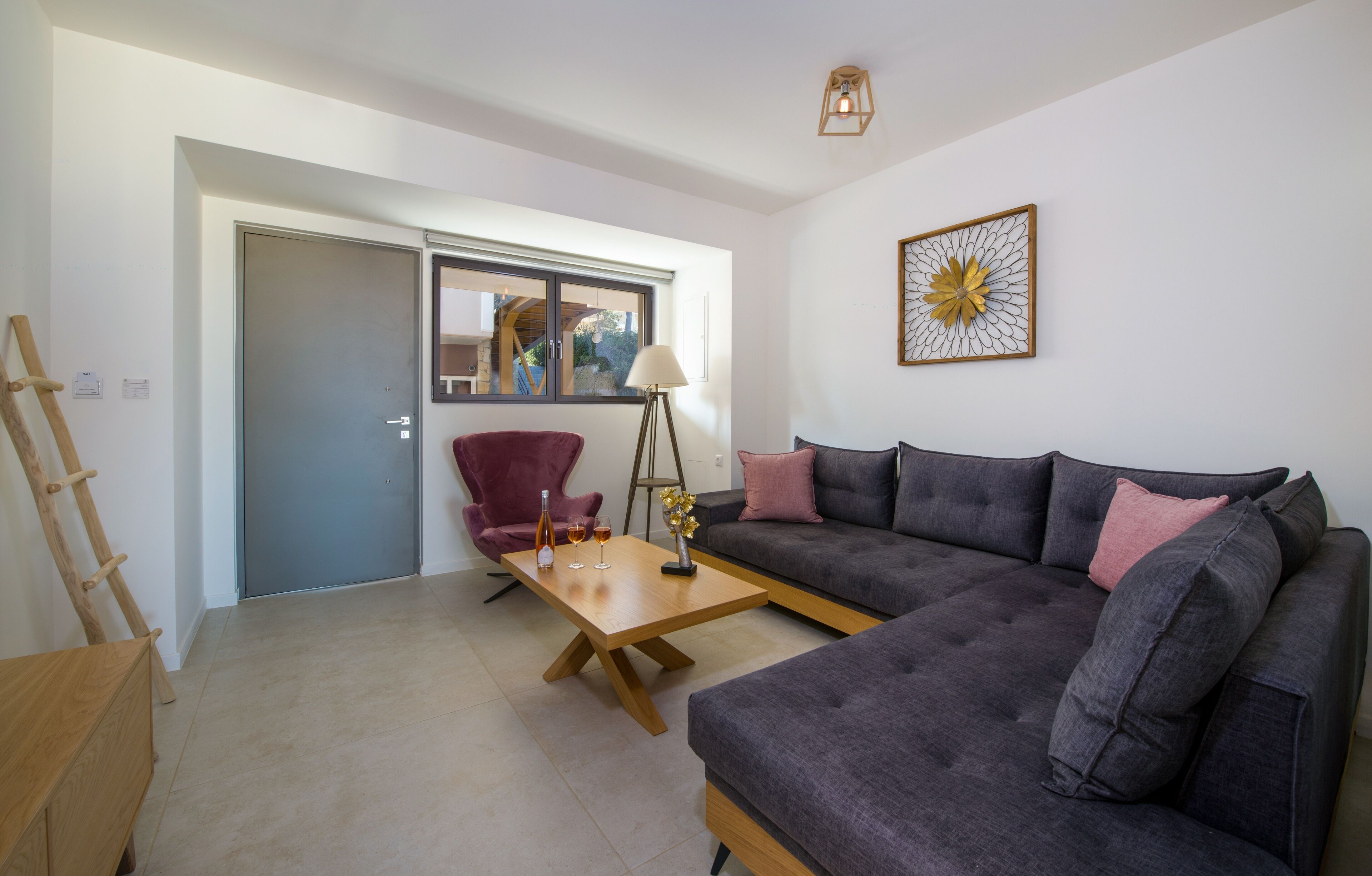 A modern living room with a grey sofa, a red armchair, and a wooden coffee table.