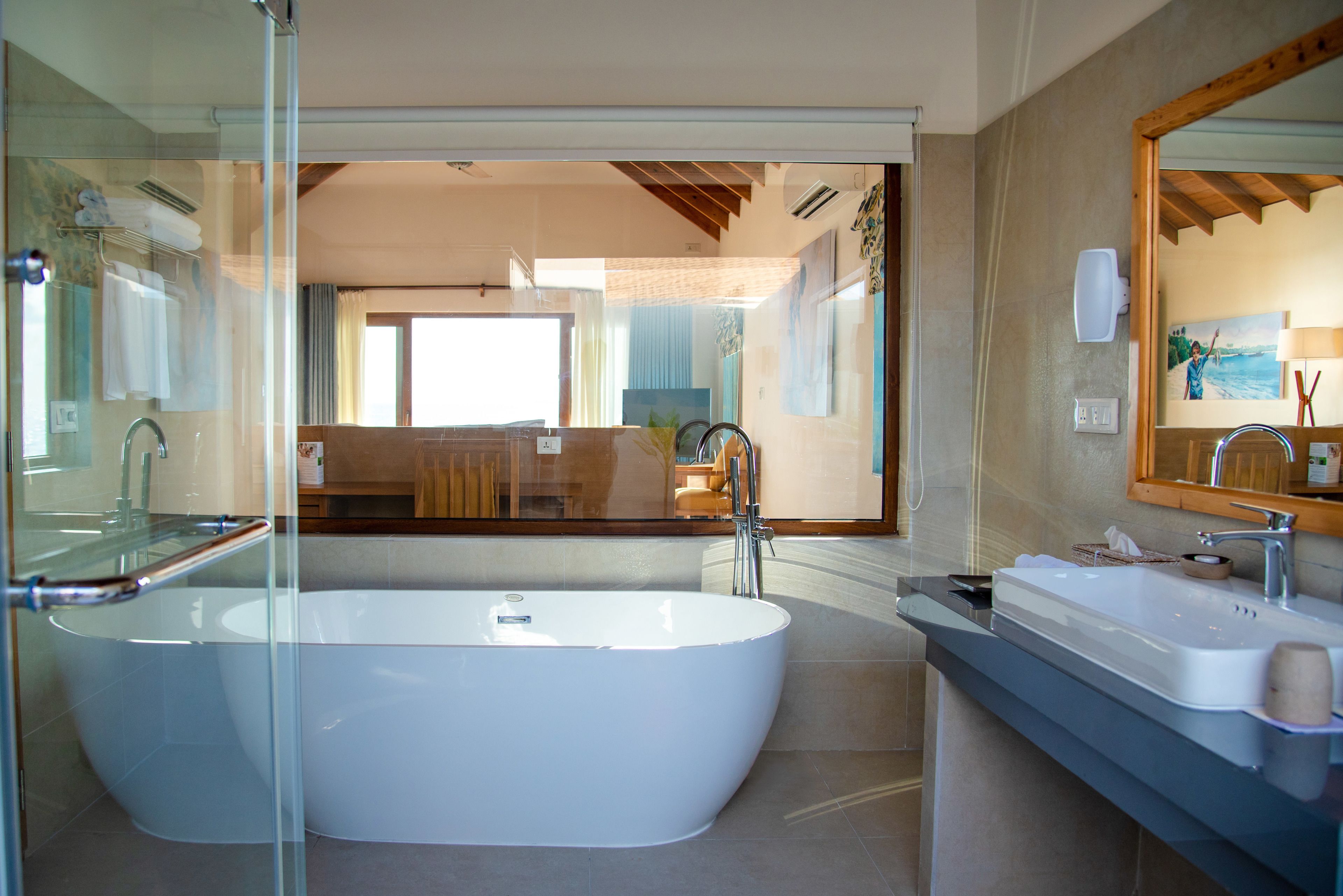 A modern bathroom with a freestanding bathtub, a glass shower enclosure, and a large mirror.