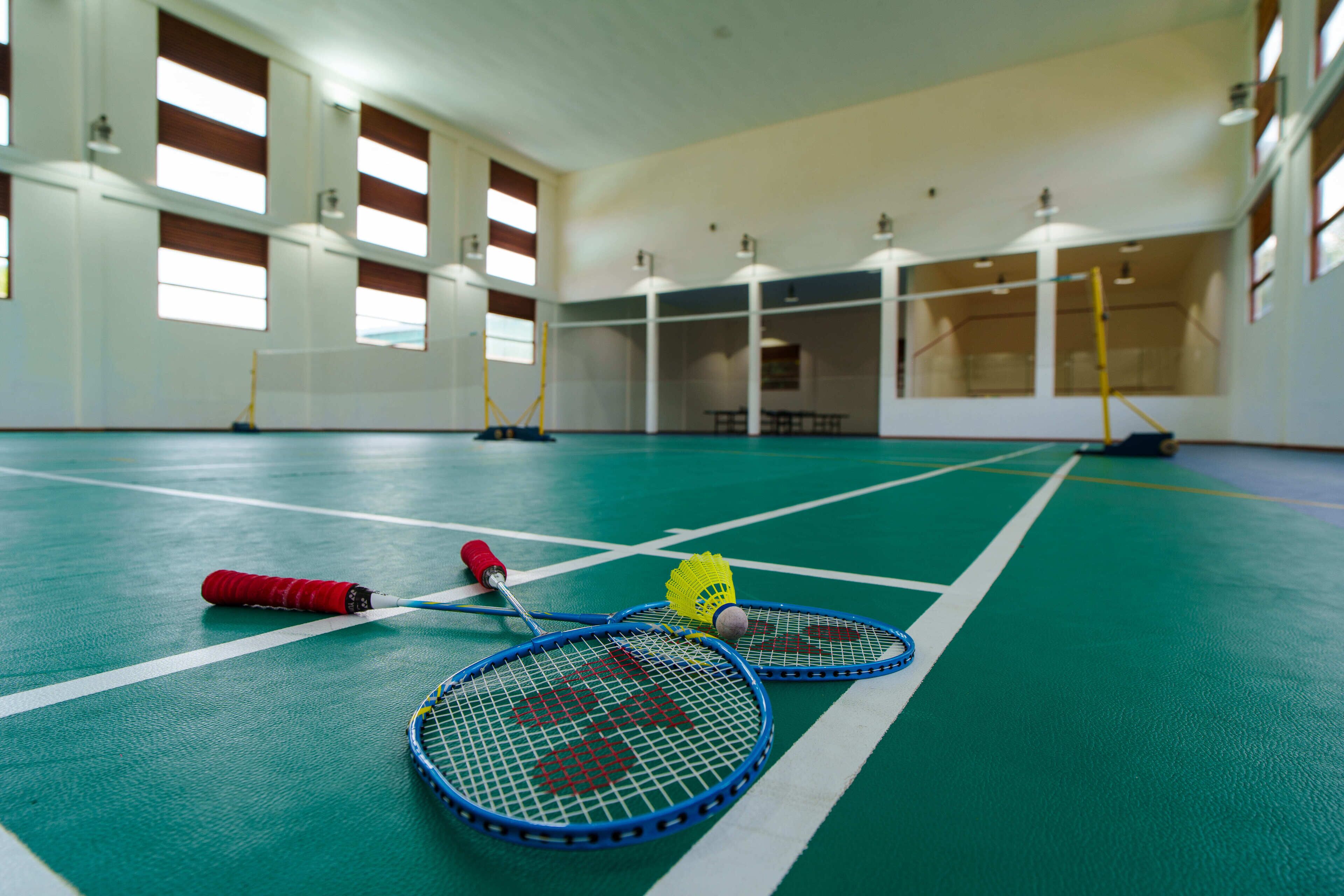 Pista cubierta para bádminton con varias raquetas y volante.
