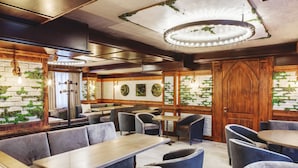 A restaurant with wooden tables and booths, brick walls, and a chandelier. - Familion Aparthotel (Chisinau)