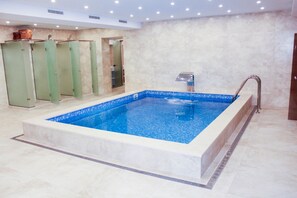 Una piscina techada, sillones reclinables de piscina