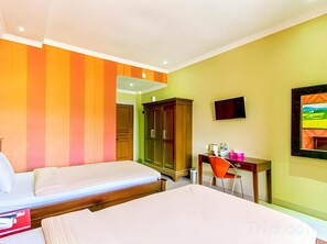 A hotel room with two beds, a desk with a chair, a TV, and a cabinet.