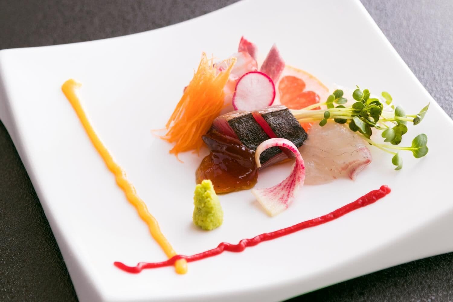 Un plato blanco con diferentes alimentos y salsas.