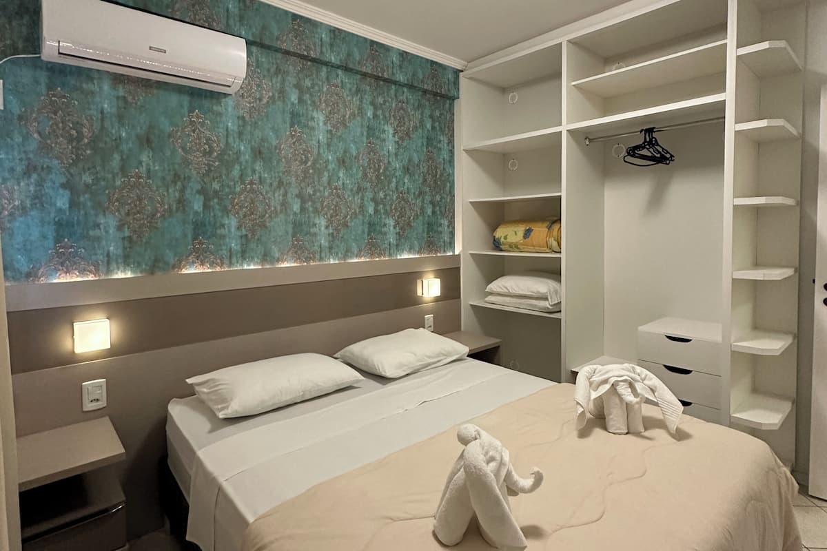 Hotellihuone, jossa on sänky, vaatekaappi ja kylpyhuone.
