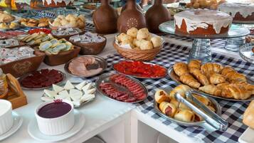 Un bufé con diversas opciones de comida, incluyendo pasteles, quesos y salsas.