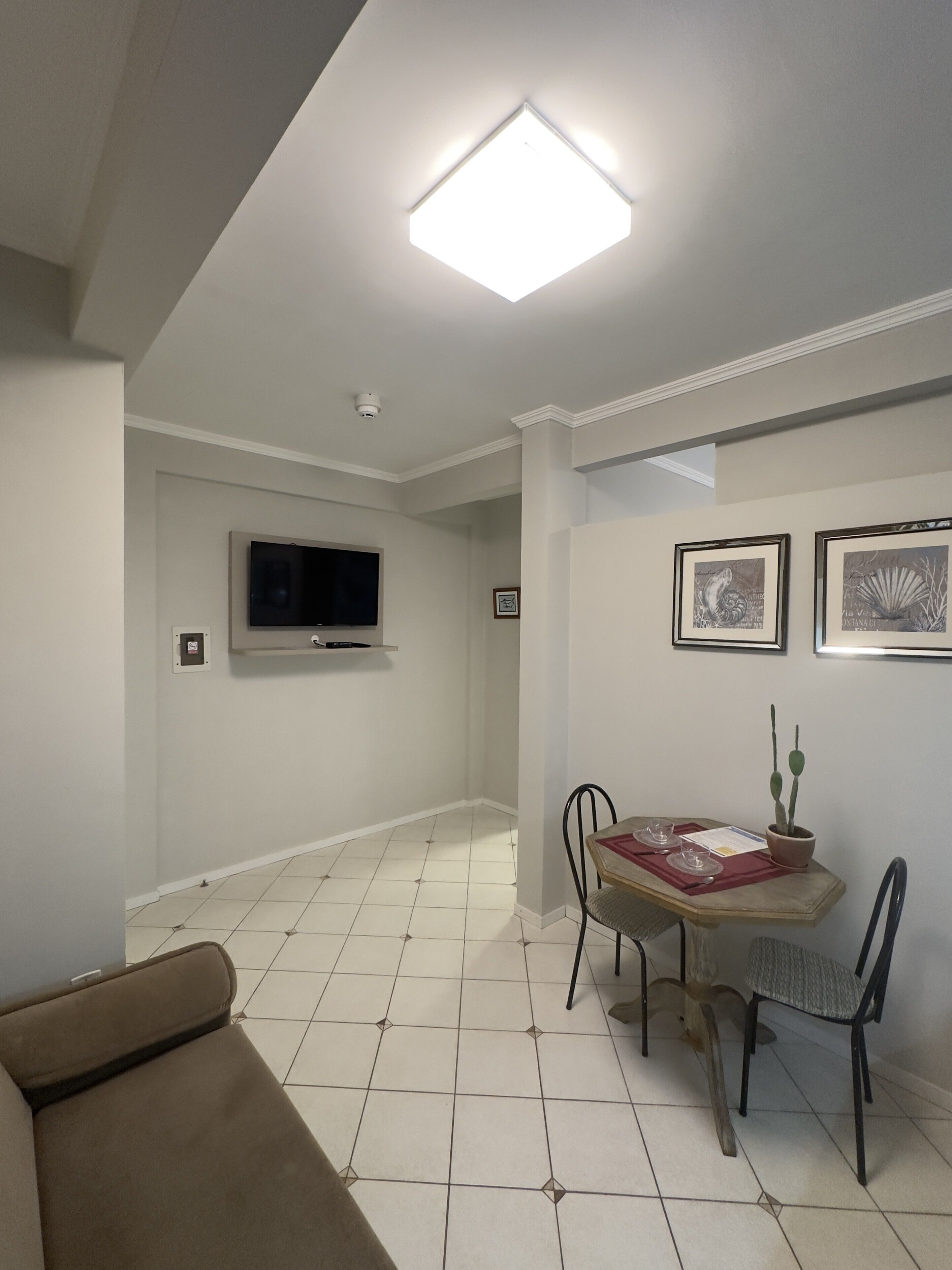 A dining area with a table, chairs, and a ceiling light.