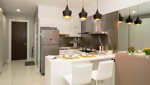 A modern kitchen with a central island, stainless steel appliances, and pendant lighting.