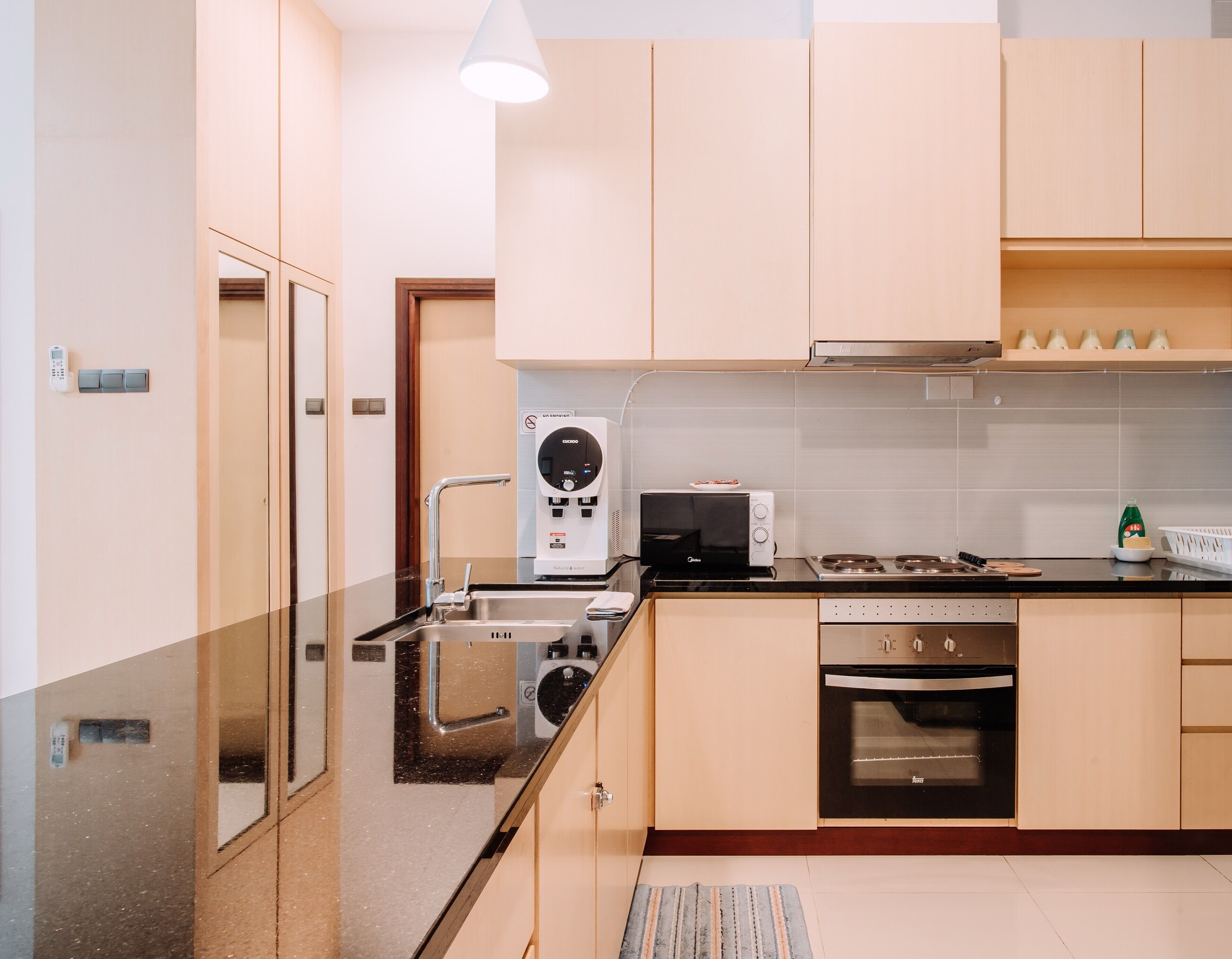 A modern kitchen with a built-in microwave, oven, and sink.