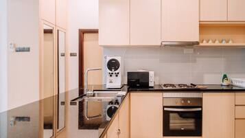 A modern kitchen with a built-in microwave, oven, and sink.