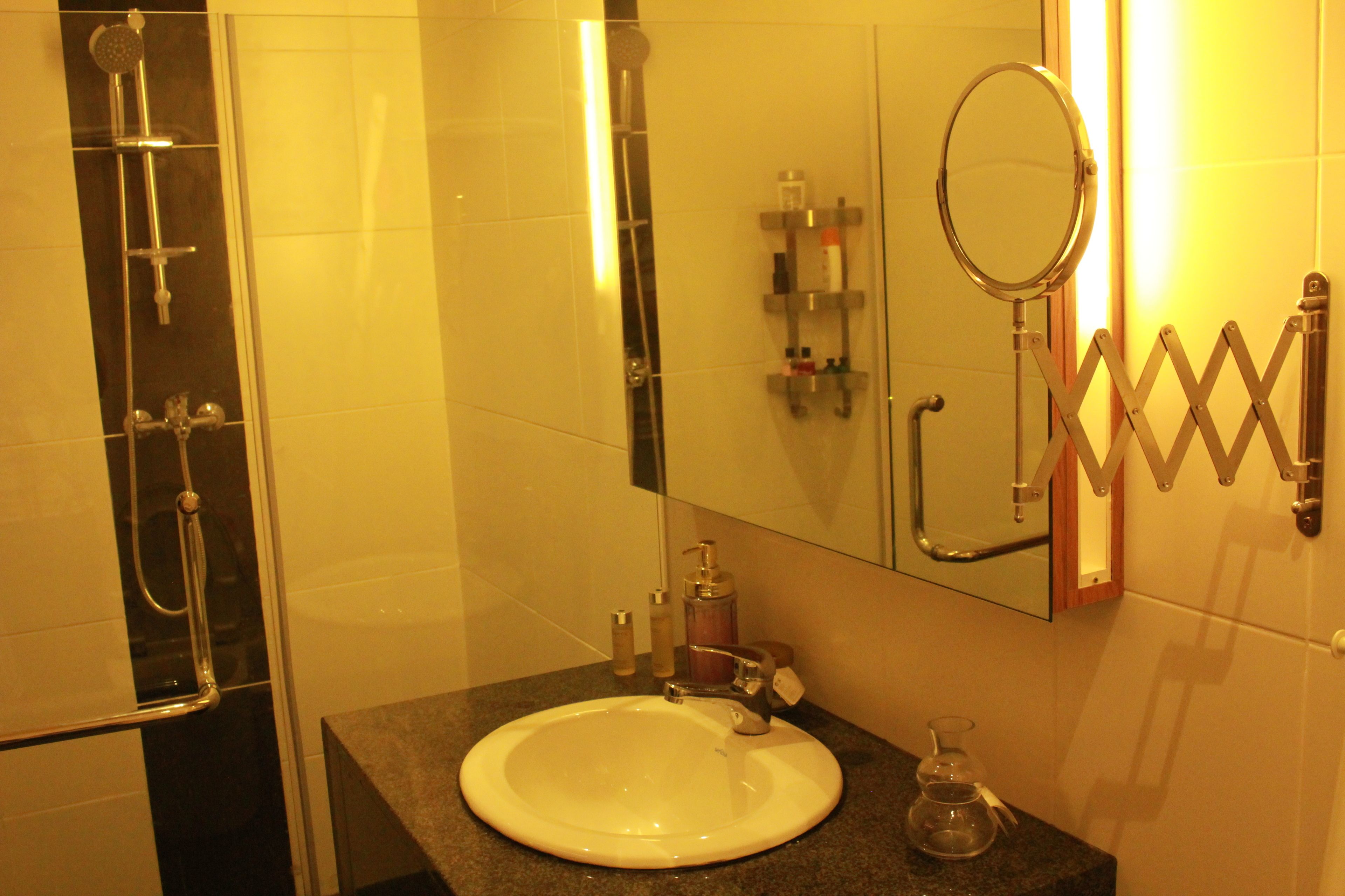 A bathroom with a white sink, a mirror, and a shower.