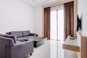 Una sala de estar moderna con un sofá, una mesa de centro y un televisor de pantalla plana montado en la pared.