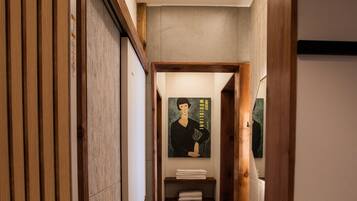 A narrow hallway with wooden paneling, a tiled floor, and a ceiling light.