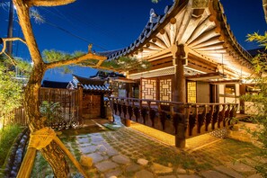A traditional Japanese building with a wooden structure, stone pathway, and a tree in the foreground. - Soi Hanok Stay (Gyeongju)