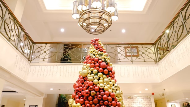 A grand lobby with a large, ornate chandelier and a decorated Christmas tree. - De Luxe Hotel (Cagayan de Oro)