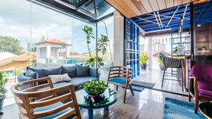 A modern living room with a glass table, wooden chairs, and a sofa. - Tien Hotel (George Town)