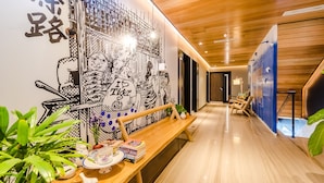 A hallway with a wooden bench, a wall mural, and a staircase. - Tien Hotel (George Town)
