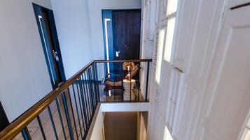 Eine Treppe mit gemusterten Stufen, einem Metallgeländer und einer Tür am oberen Ende.