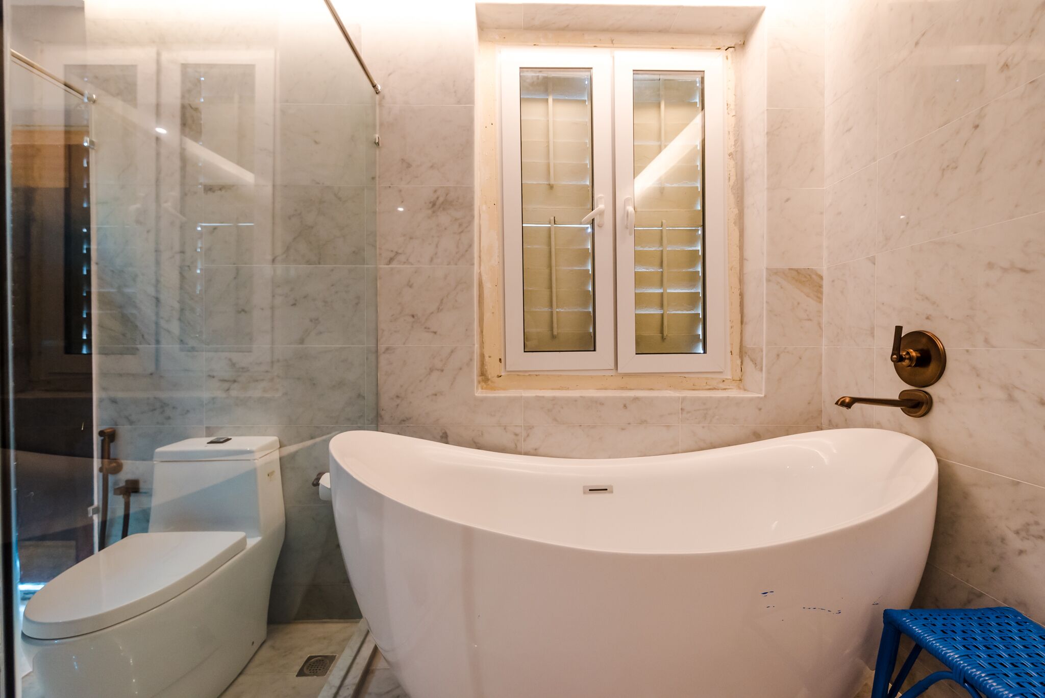 A bathroom with a bathtub, toilet, and glass shower enclosure.
