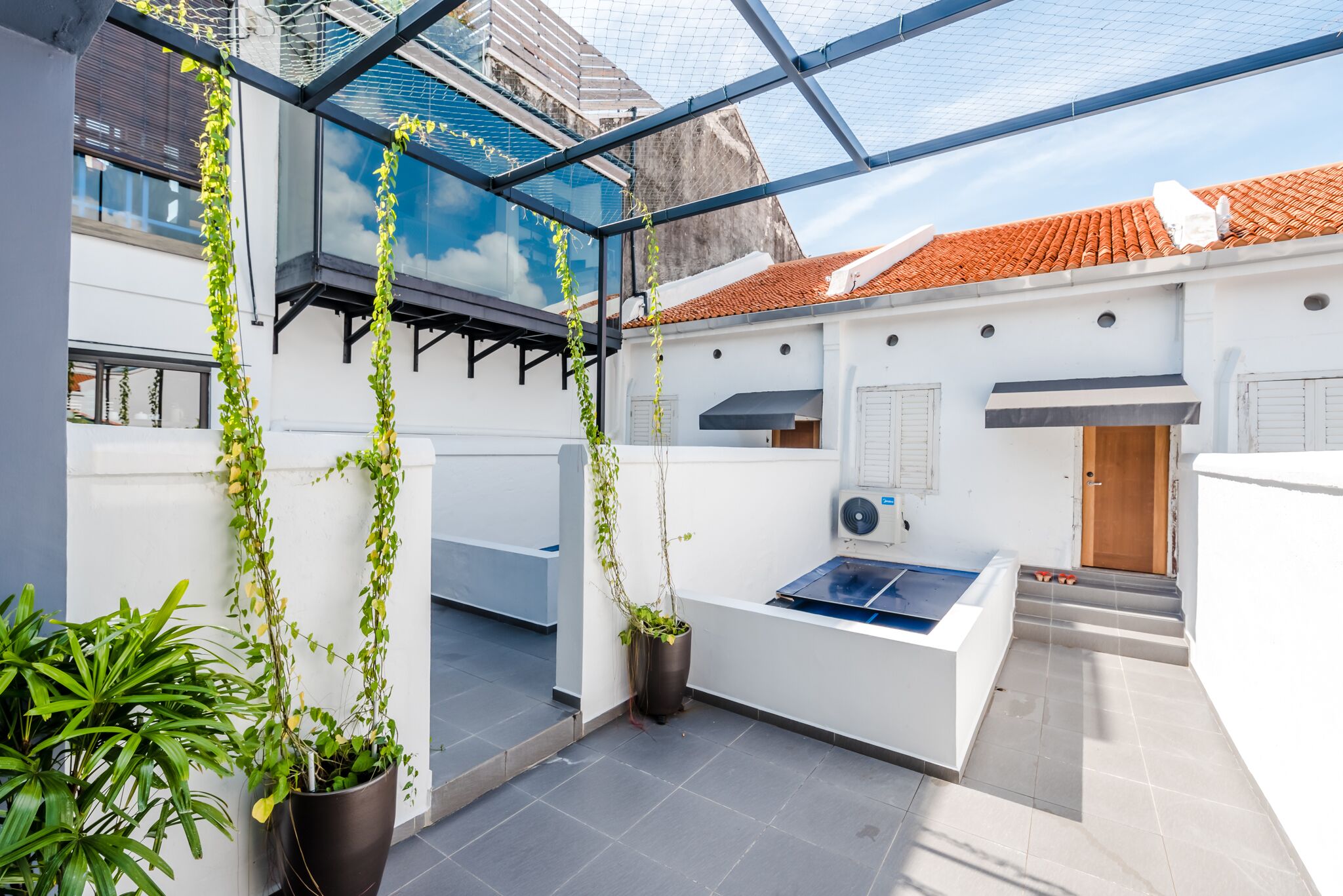 A modern rooftop terrace with potted plants, a pool table, and a view of the cityscape.