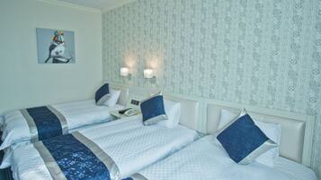 A hotel room with two beds, a nightstand, and a painting on the wall.