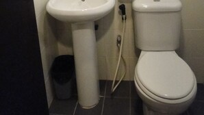 Ein Badezimmer mit Waschbecken, Spiegel, Toilette und Handtuchhalter.