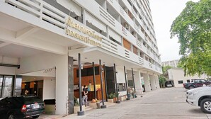 Un hotel moderno a più piani con facciata contemporanea, un'area reception e un parcheggio.