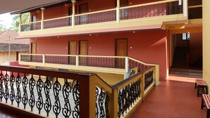Un edificio de dos pisos con balcones, barandillas y puertas de madera.