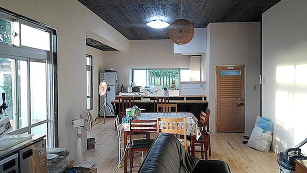 Ein kompakter Wohnbereich mit Essbereich, Küchenzeile und großem Fenster für natürliches Licht.